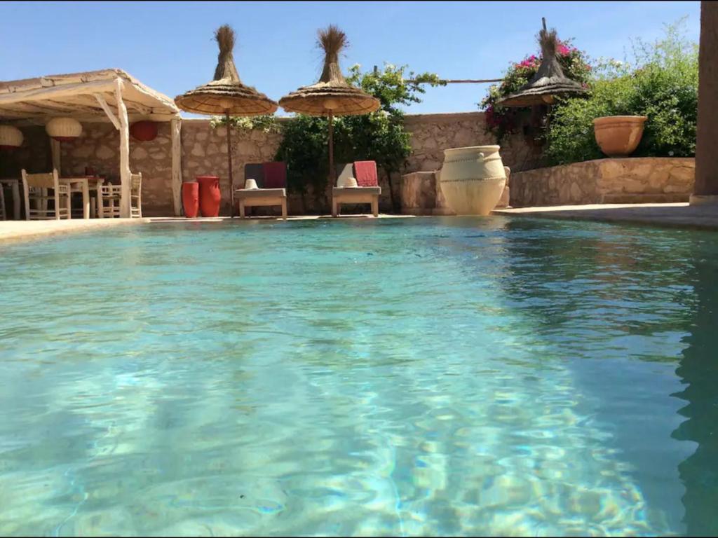 una gran piscina con sillas y sombrillas en Villa 202 commentaires 5 étoiles sur 3 sites, en Essaouira