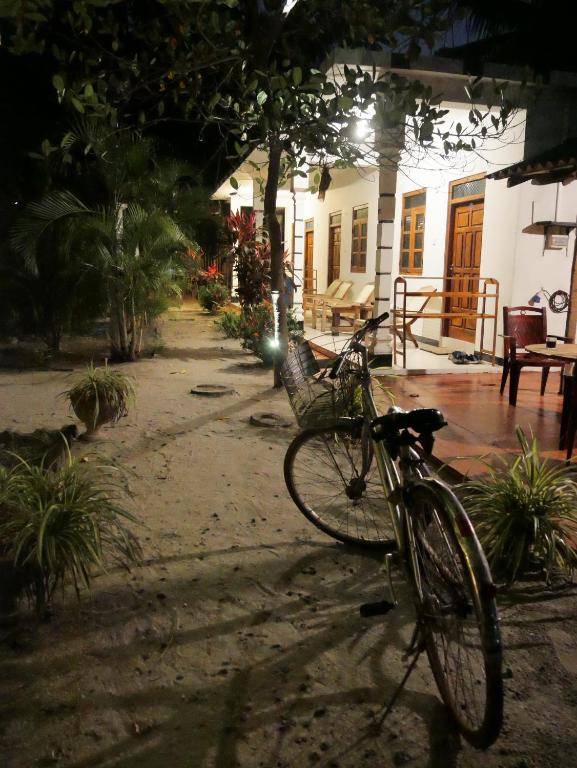 Una bicicleta estacionada frente a una casa por la noche en Ubay Guest House, en Trincomalee