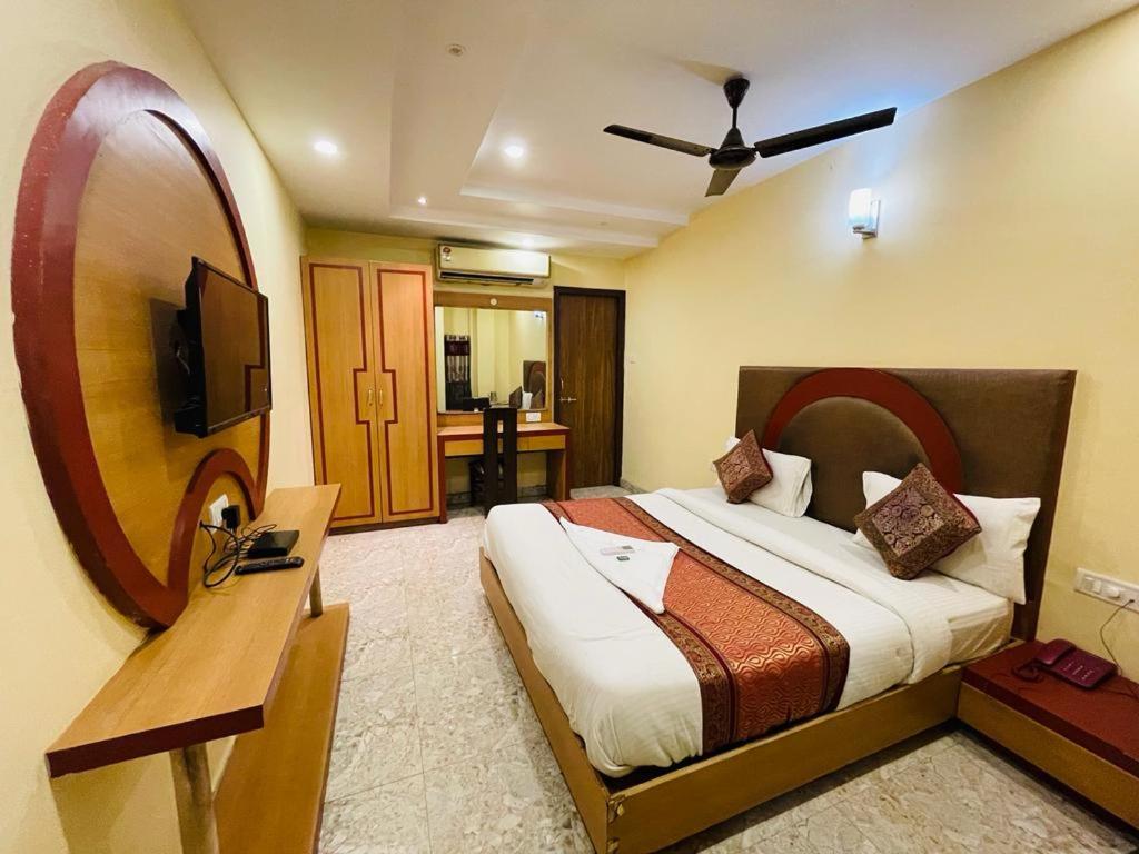 a hotel room with a bed and a mirror at HOTEL AUGUSTO in Varanasi