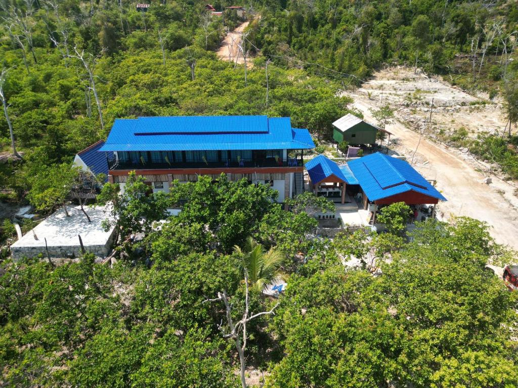 Top View Kohrong في Phumĭ Kâoh Rŏng: اطلالة جوية على مبنى بسقف ازرق