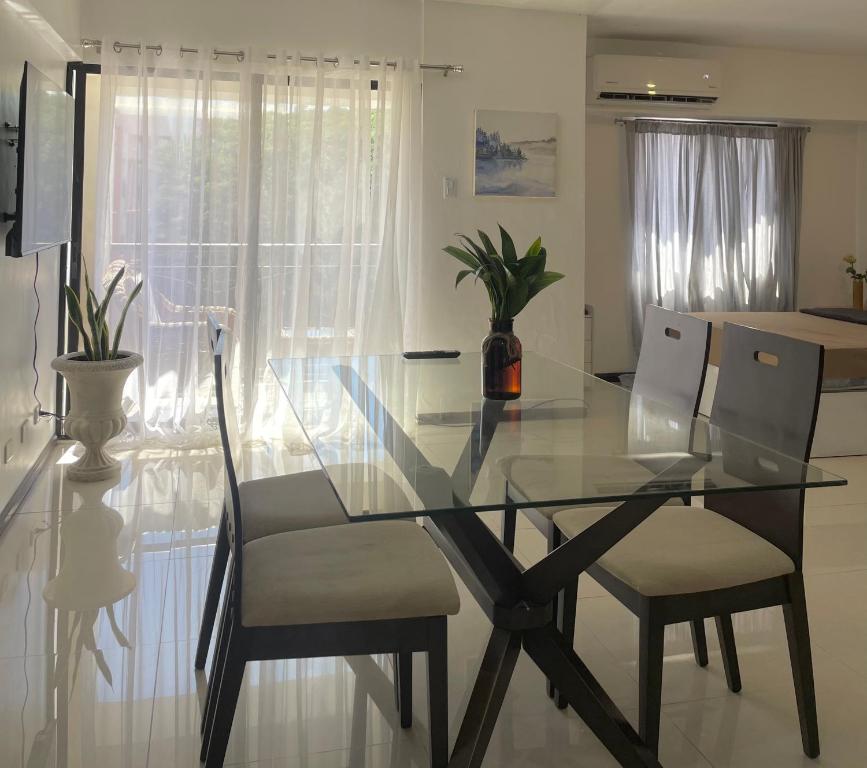 uma mesa de vidro e cadeiras numa sala de estar em The Premier Suite em Pusok