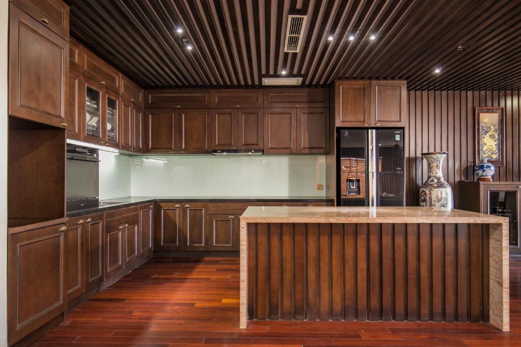 a large kitchen with wooden cabinets and a island at Palazzo Boutique Hotel in Danang