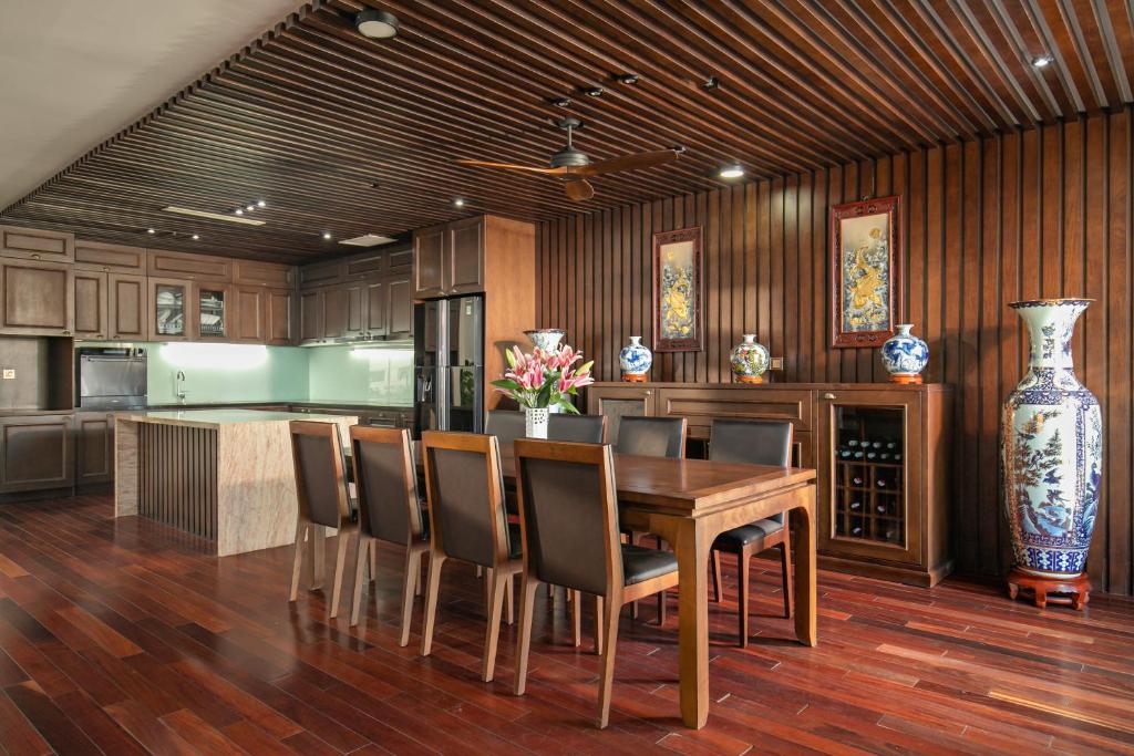a kitchen with a table and chairs and a vase at Palazzo Boutique Hotel in Danang