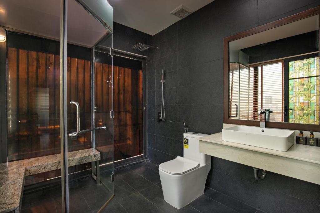 a bathroom with a toilet and a shower and a sink at Palazzo Boutique Hotel in Danang