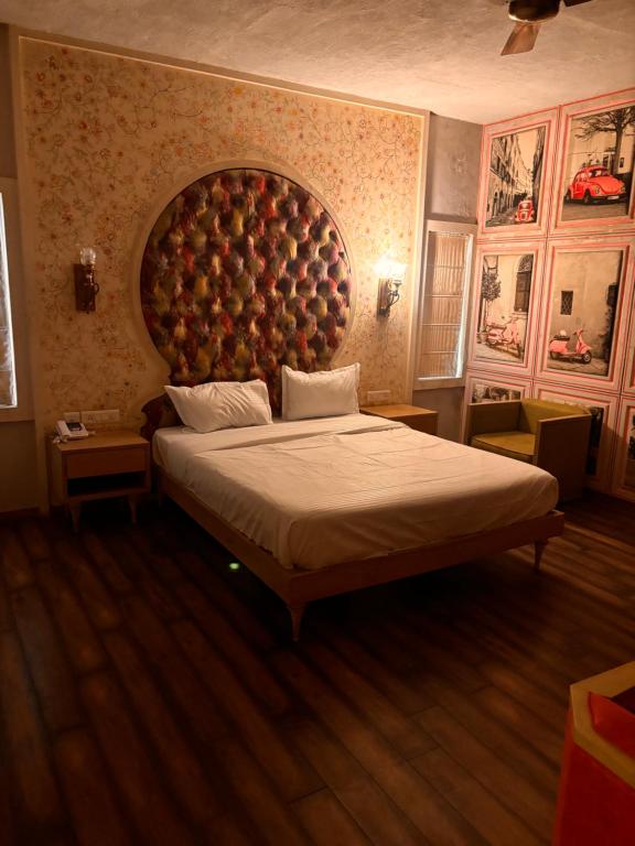 HOTLE MEHAI SWEET HOUSE في جايبور: غرفة نوم بسرير كبير مع اللوح الأمامي كبير