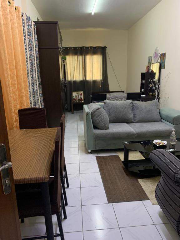 a living room with a couch and a table at Studio Apartment in Sharjah