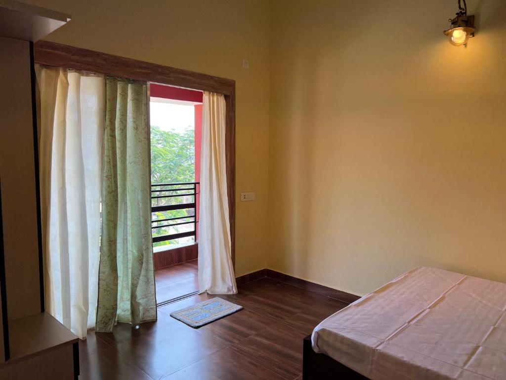 a bedroom with a bed and a large window at Sreemati - A Tranquil Villa in Shānti Niketan