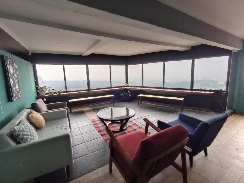 sala de estar con sofás, sillas y mesa en Villa Ambu, en Bandung