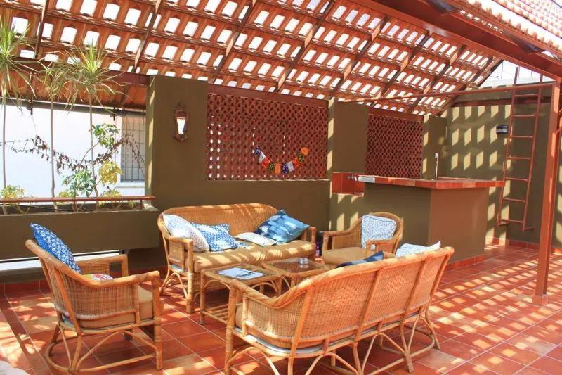 a patio with a couch and a table and chairs at Jugglers Rest - Villa in Bangalore