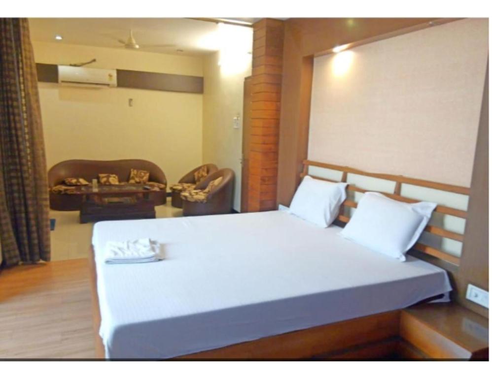 a bedroom with a large white bed in a room at Hotel Beena Mansion, Darbhanga in Darbhanga