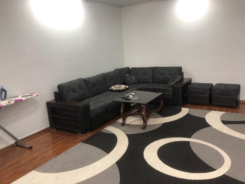 uma sala de estar com um sofá e uma mesa em Айбек 20 em Yakkasaray