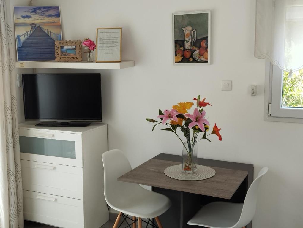 une salle à manger avec une table avec un vase de fleurs dans l'établissement Vacances à la mer., à Six-Fours-les-Plages