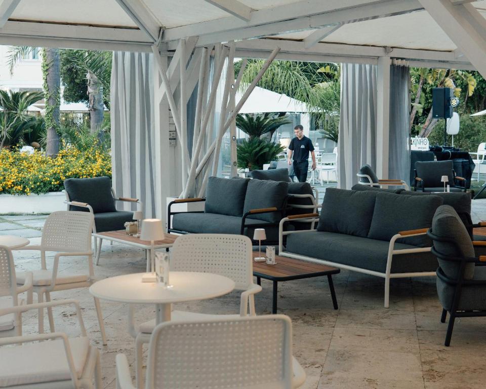 a lobby with couches and tables and a man in the background at Relais Corte Degli Aragonesi in Ischia