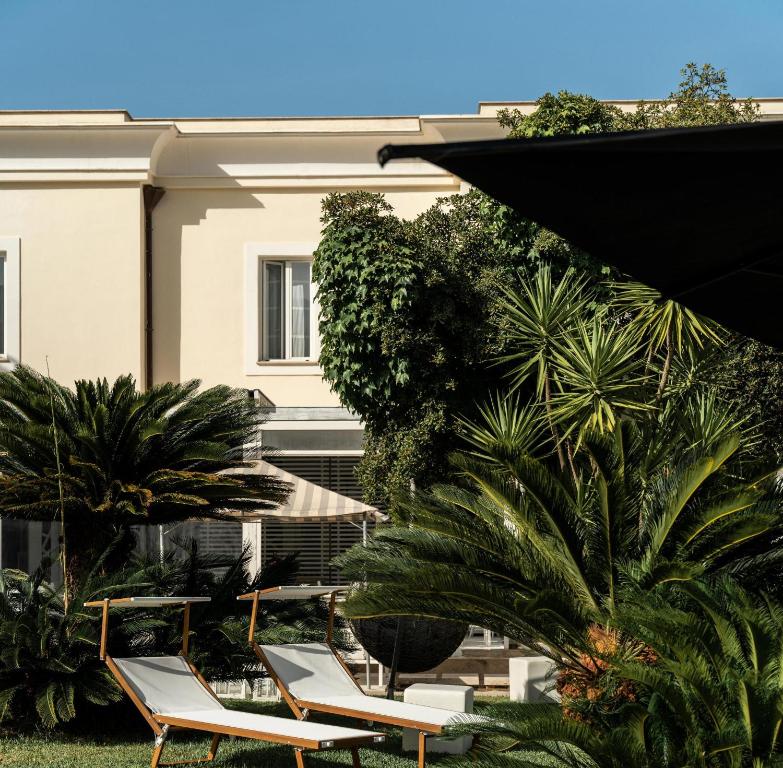 a group of chairs and umbrellas in front of a building at Relais Corte Degli Aragonesi in Ischia