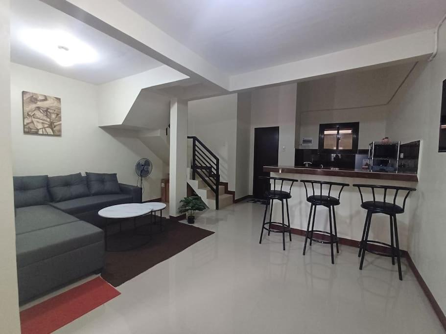 sala de estar con sofá, mesa y cocina en Affordable 2 BR Transient House in Lipa City Batangas en Lipa