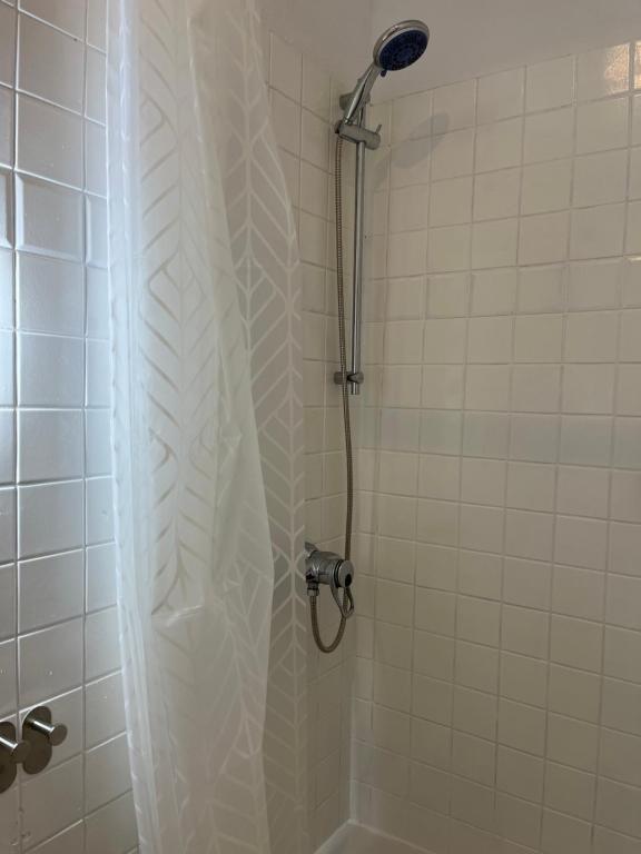 a shower with a white shower curtain in a bathroom at Traumhaftes City Apartment in Viersen