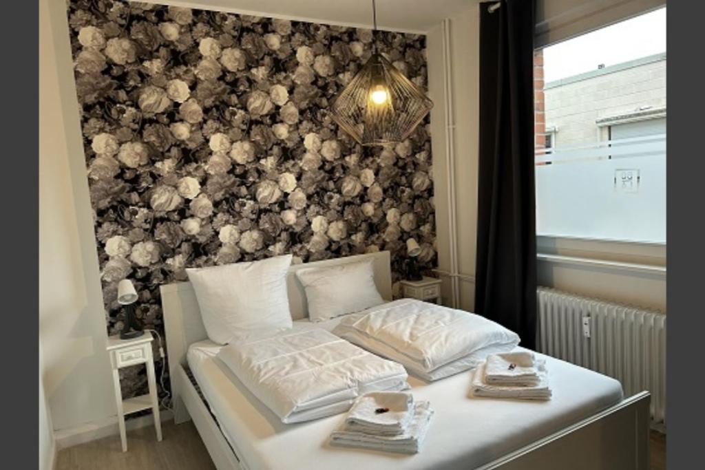a bedroom with a bed with a wall covered in flowers at Ferienwohnung Rose 42 Citynah, gehobene Ausstattung in Hamburg