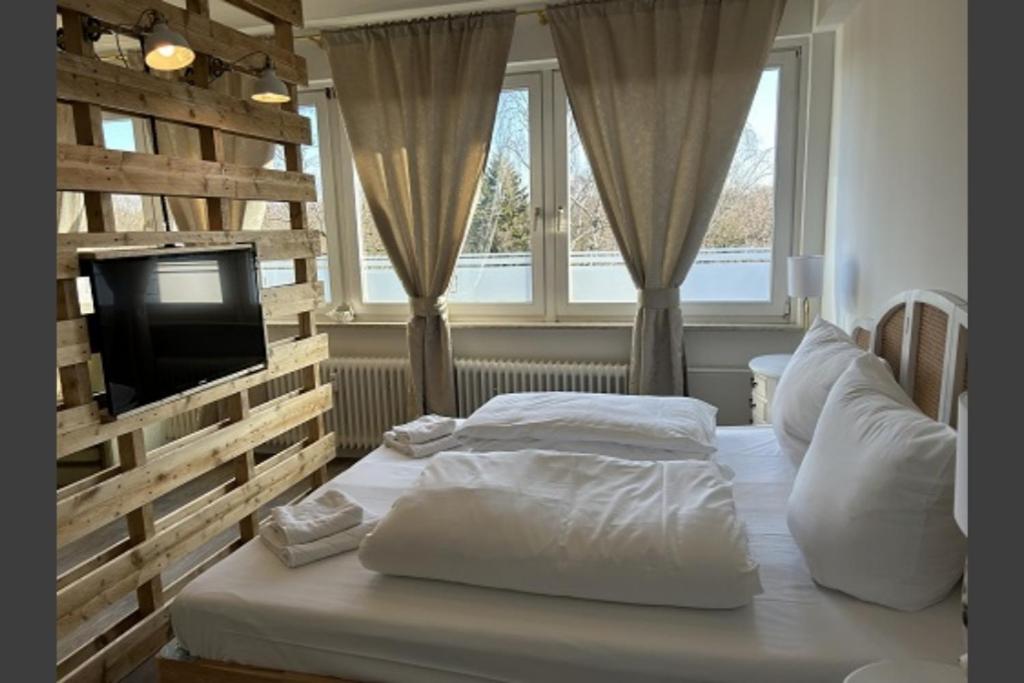 1 Schlafzimmer mit 2 weißen Betten und einem TV in der Unterkunft Studio-Apartment Shabby 47 Citynah, Retro & modern in Hamburg