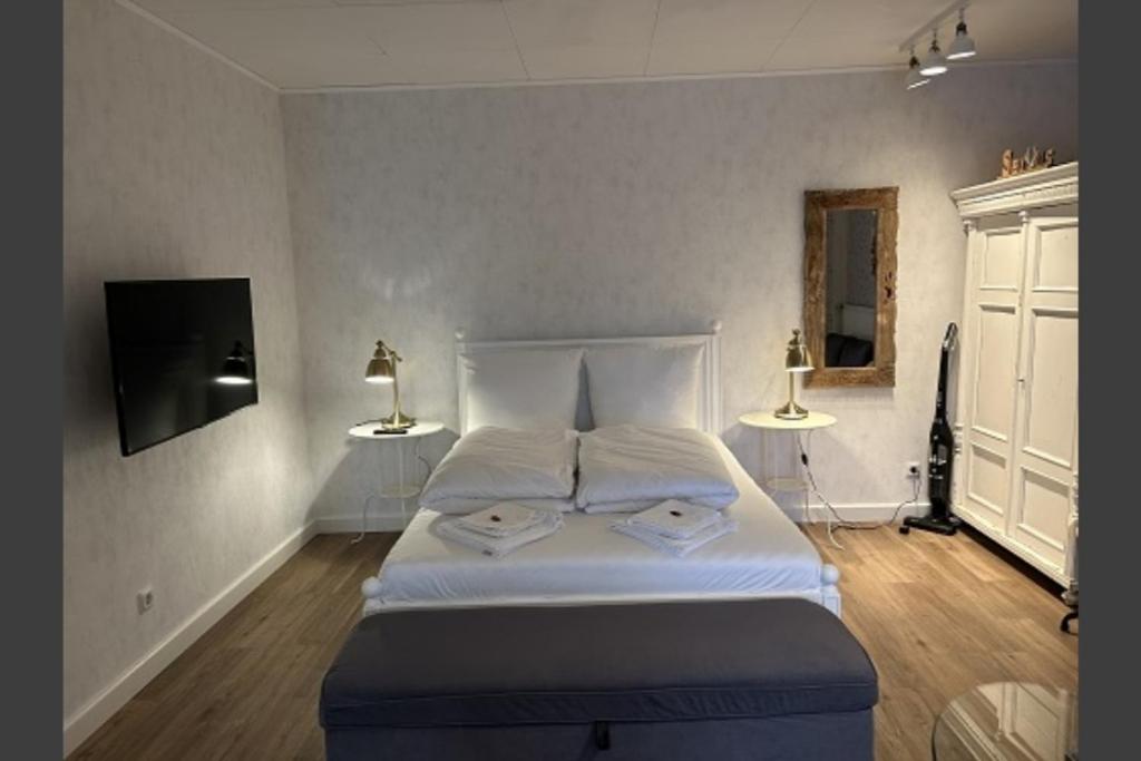 a bedroom with a large white bed with two lamps at Studio- Apartment Hirschwiese 52 "cozy" für zwei in Hamburg