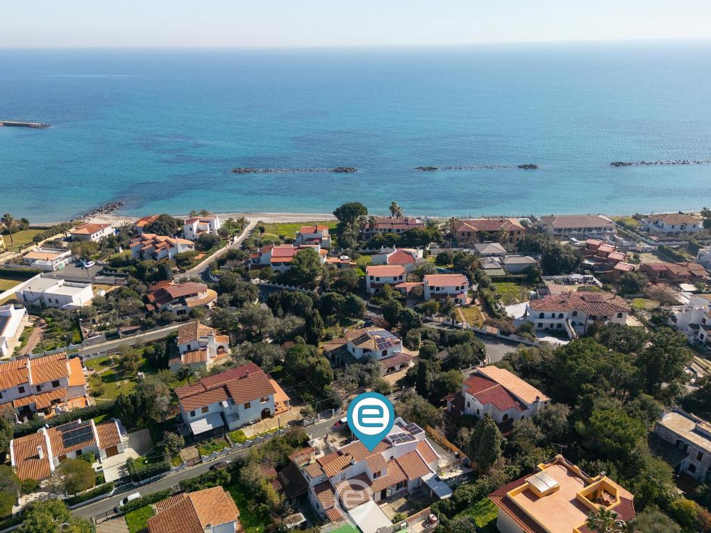 una vista aérea de una pequeña ciudad con casas y el océano en Angelica's beachside apartment, en Porto Columbu - Perdʼe Sali
