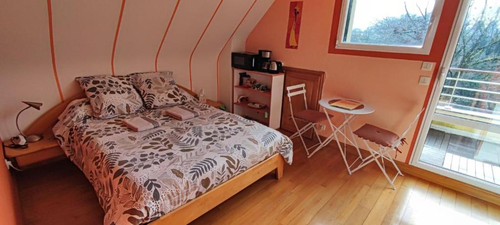 sypialnia z łóżkiem, stołem i oknem w obiekcie 2 Belles chambres avec balcon sdb et WC privatifs w mieście Lannion