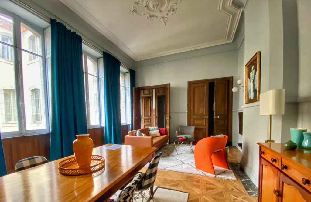 CARCASSONNE HISTORIC DUPLEX 4 star air conditioned APARTEMENT d`ÉGLANTINE في قرقشونة: غرفة طعام مع طاولة وغرفة معيشة