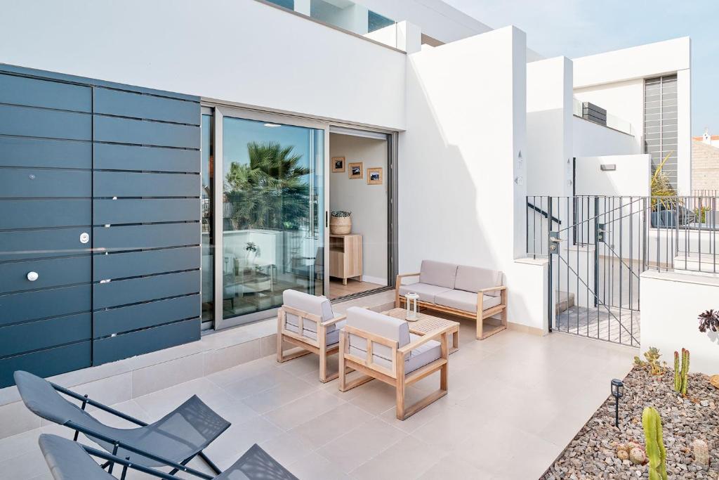 a patio with chairs and a table on a building at CASA LA BOTAVARA - Pool & Beach in Abades
