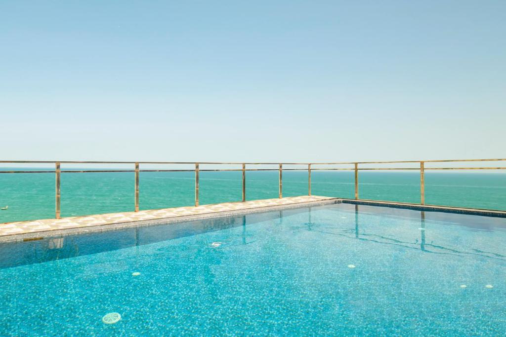a swimming pool with the ocean in the background at Palazzo Boutique Hotel in Danang