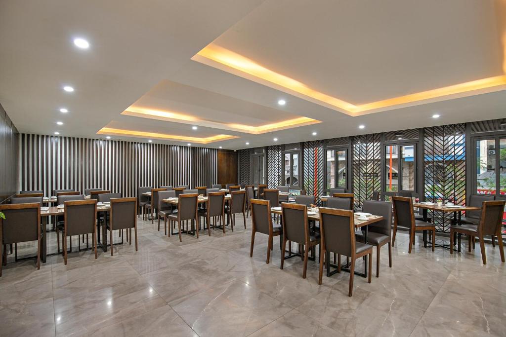 a dining room with tables and chairs and windows at Palazzo Boutique Hotel in Danang