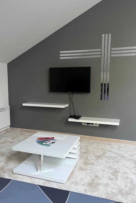 布達考拉斯的住宿－Chill apartman，客厅配有电视和白色咖啡桌。
