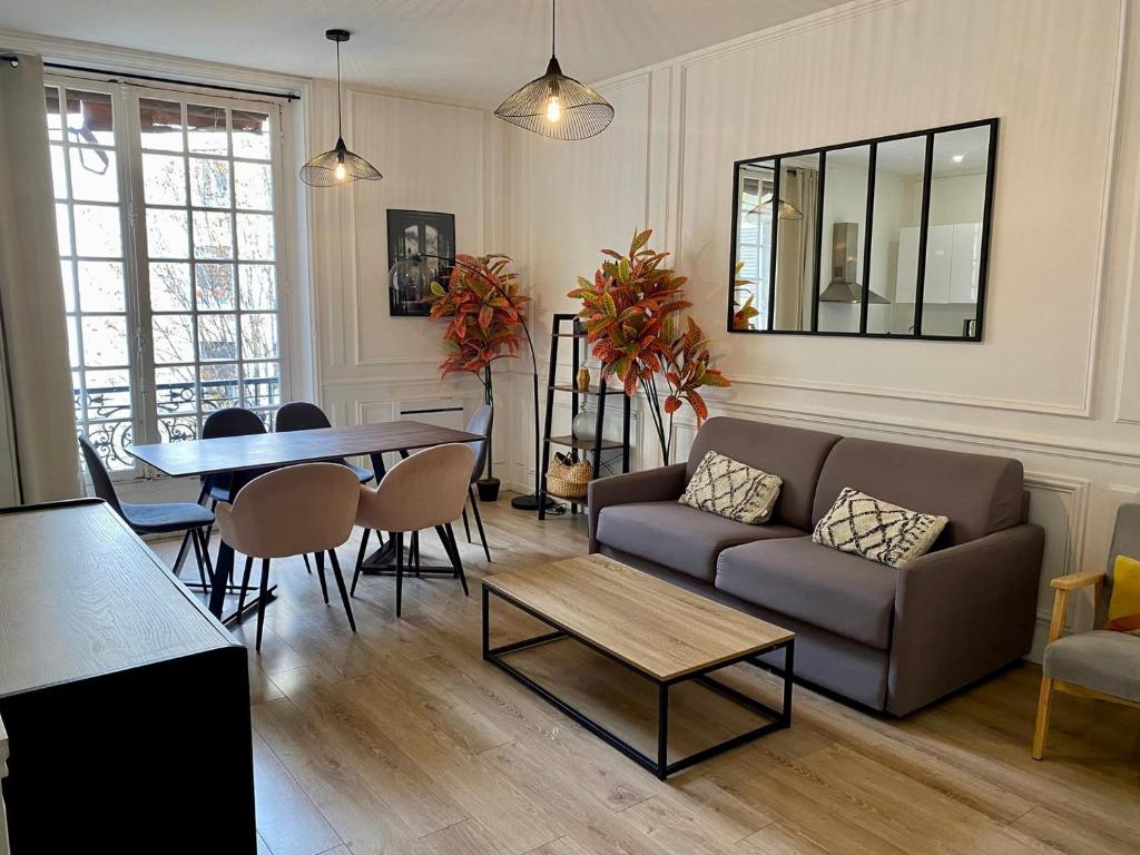 un salon avec un canapé et une table dans l'établissement Cocooning appartement à côté Champs-Elysée, à Paris