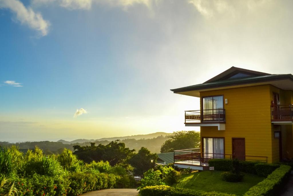 a yellow house with a view of the mountains at Hotel Ficus - Monteverde in Monteverde Costa Rica