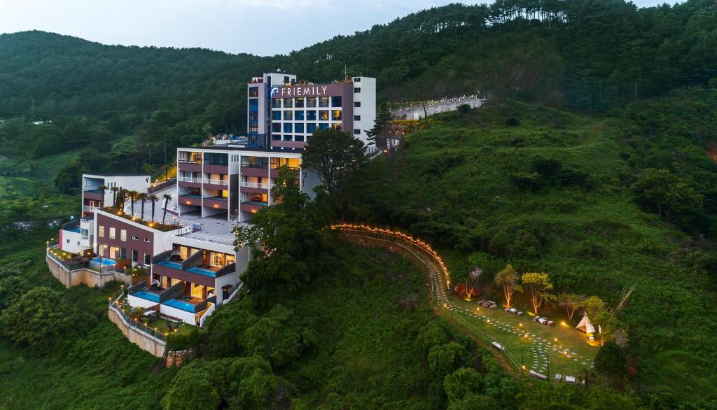 ein Hotel auf einem Hügel mit einem Gebäude in der Unterkunft Friemily Pool Villa & Hotel in Geoje