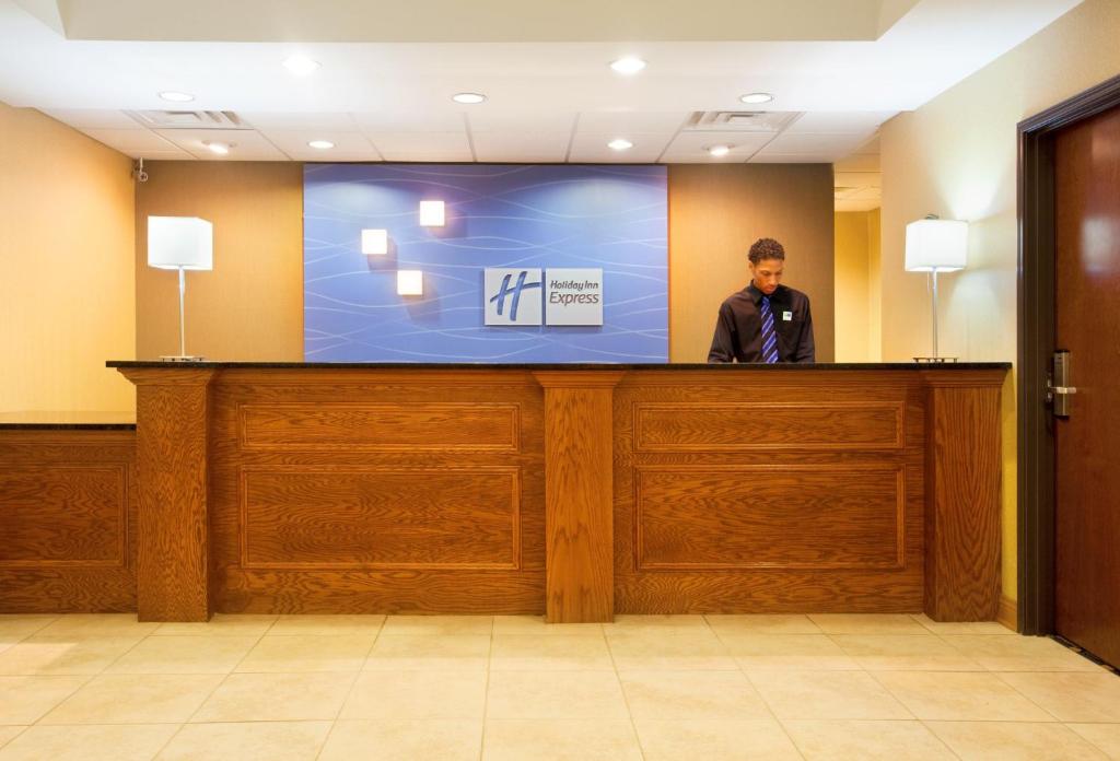 a man standing behind a large screen behind a counter at Holiday Inn Express Hotel & Suites Chicago South Lansing, an IHG Hotel in Lansing