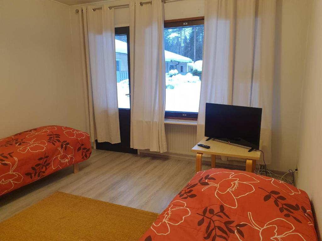 a bedroom with a bed and a desk with a computer at Saunallinen rivitalohuoneisto B5 59m2 in Säviä