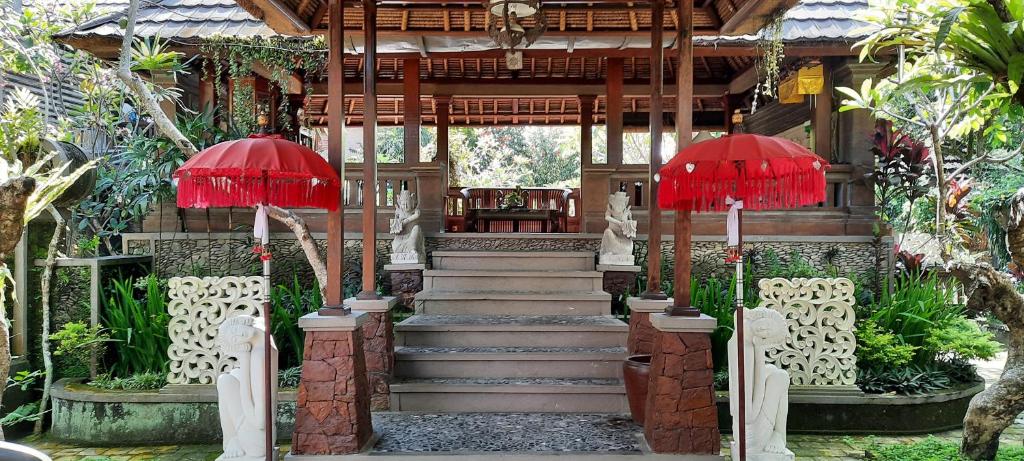 una casa con dos sombrillas rojas y una escalera en Nefatari Exclusive Villas, en Ubud