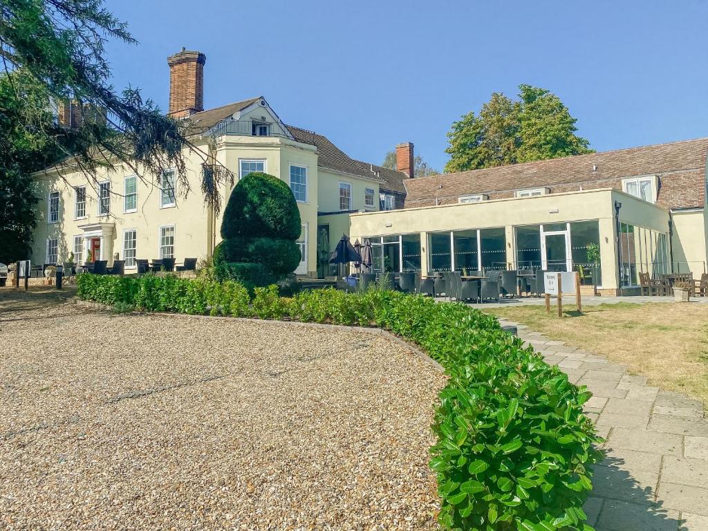 a house and a building with a gravel driveway at Best Western Priory Hotel in Bury Saint Edmunds