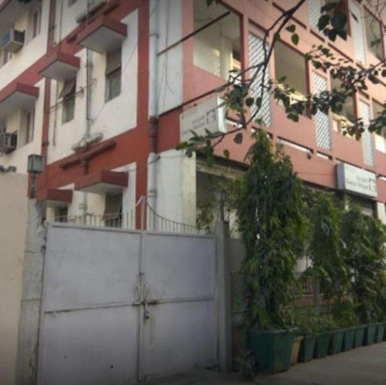 un bâtiment avec une porte blanche devant lui dans l'établissement Kastle Guest House, à New Delhi