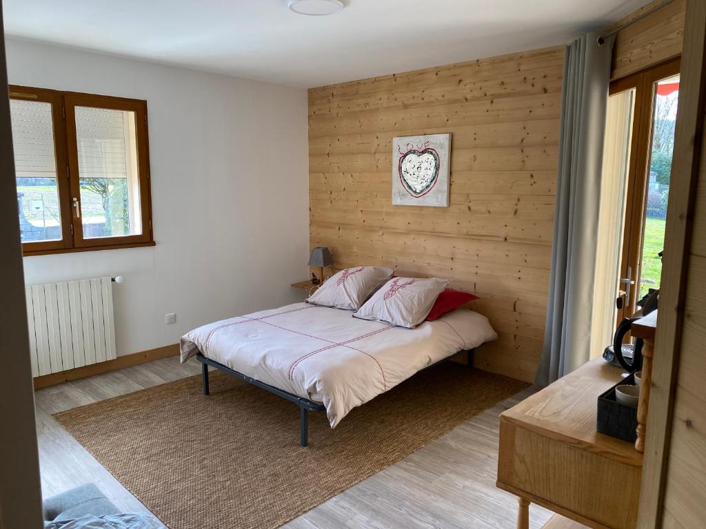 sypialnia z łóżkiem z drewnianą ścianą w obiekcie Chambre de la Tournette w mieście Saint-Jorioz