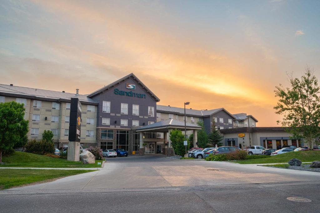 ein Hotelgebäude mit einem Parkplatz davor in der Unterkunft Sandman Hotel & Suites Calgary South in Calgary