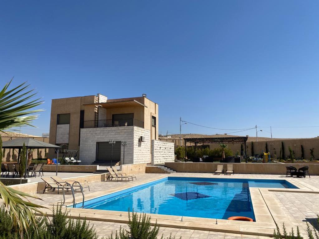 a large swimming pool in front of a building at Madaba hills Villa in Dulaylat al Ḩamāʼidah