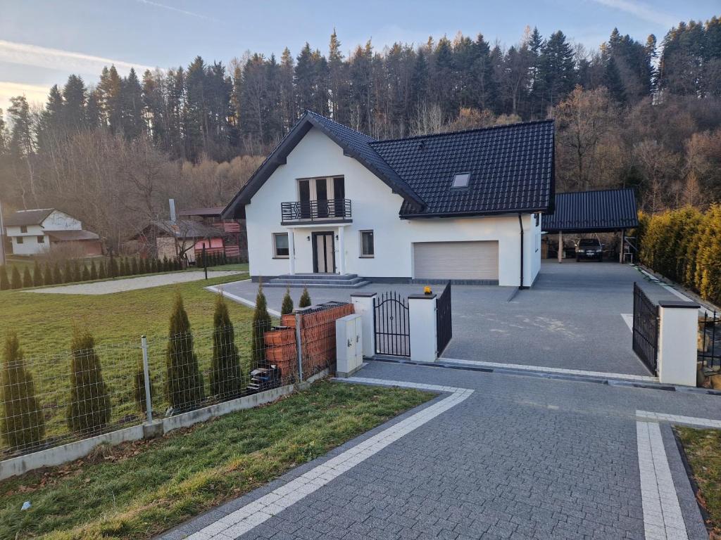 a white house with a black roof and a driveway at ZuMiLu House in Zagórz