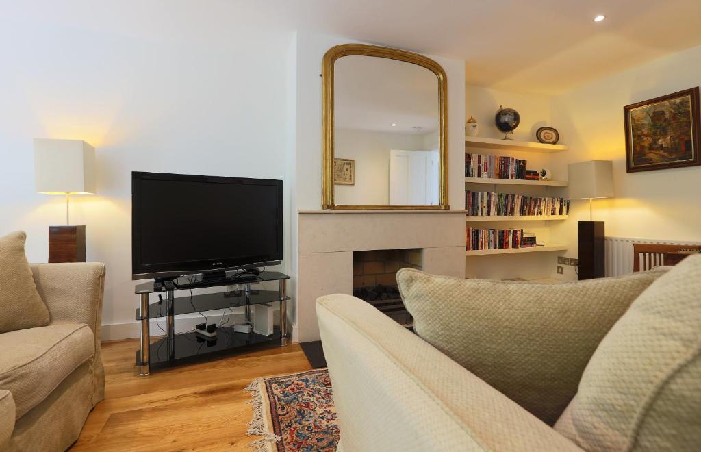 een woonkamer met een televisie en een open haard bij Period Character with Modern Comforts In Monkstown in Blackrock