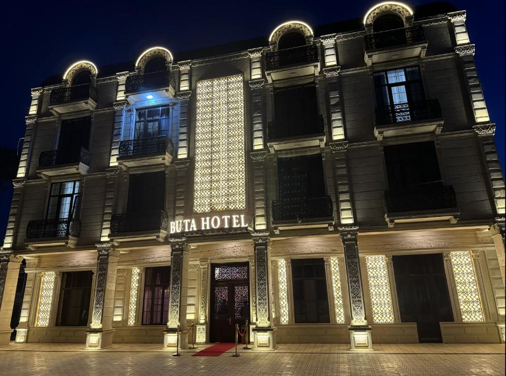 a building with the words with hotel lit up at night at Buta Hotel Berde in Bǝrdǝ