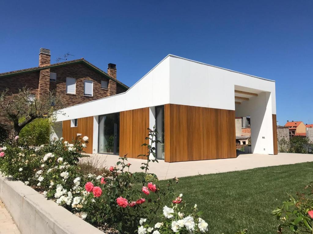 Casa con techo blanco y puertas de madera en Passivhaus con jardín en La Rioja, en Entrena