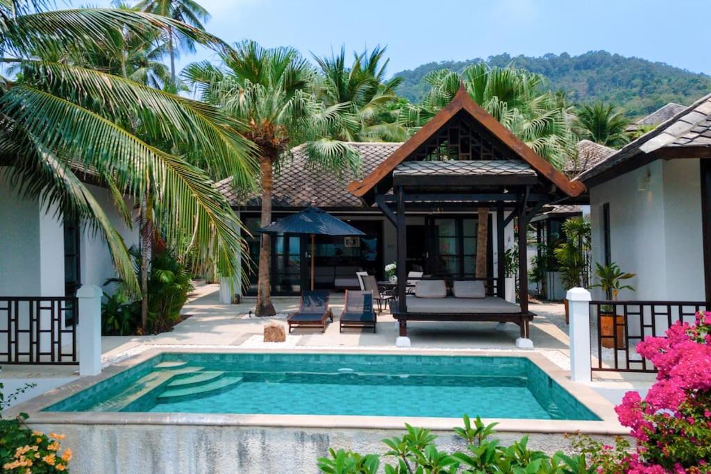 a villa with a swimming pool and a house at Privatbeach residences villa 29 in Koh Samui 