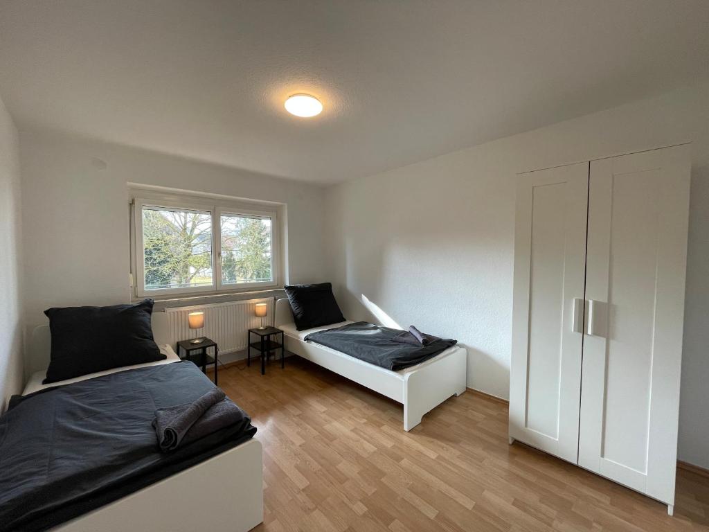 a bedroom with two beds and a window at Worker Apartments near Ulm bis zu 11 Betten in Dornstadt