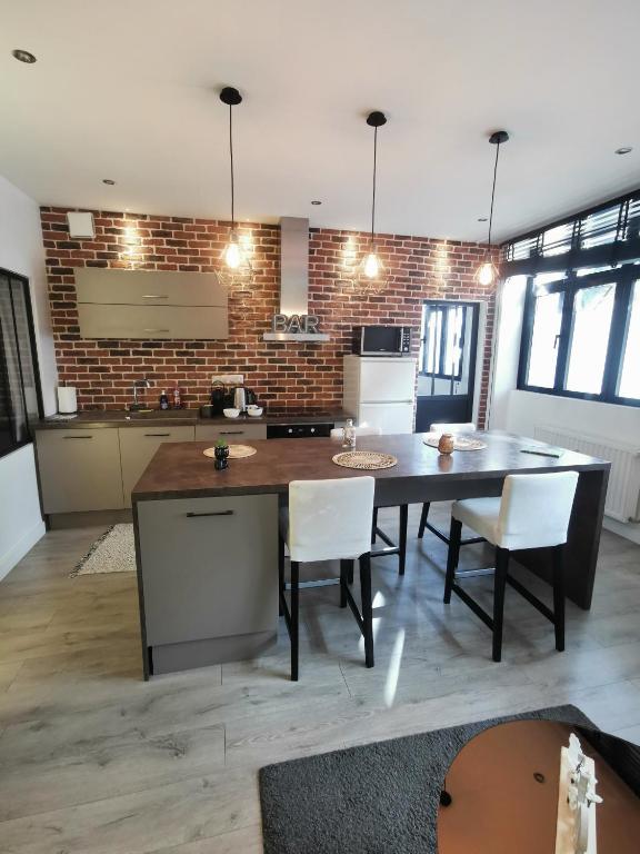 une cuisine avec une table et des chaises ainsi qu'un mur en briques dans l'établissement Le petit Brooklyn, à Strasbourg