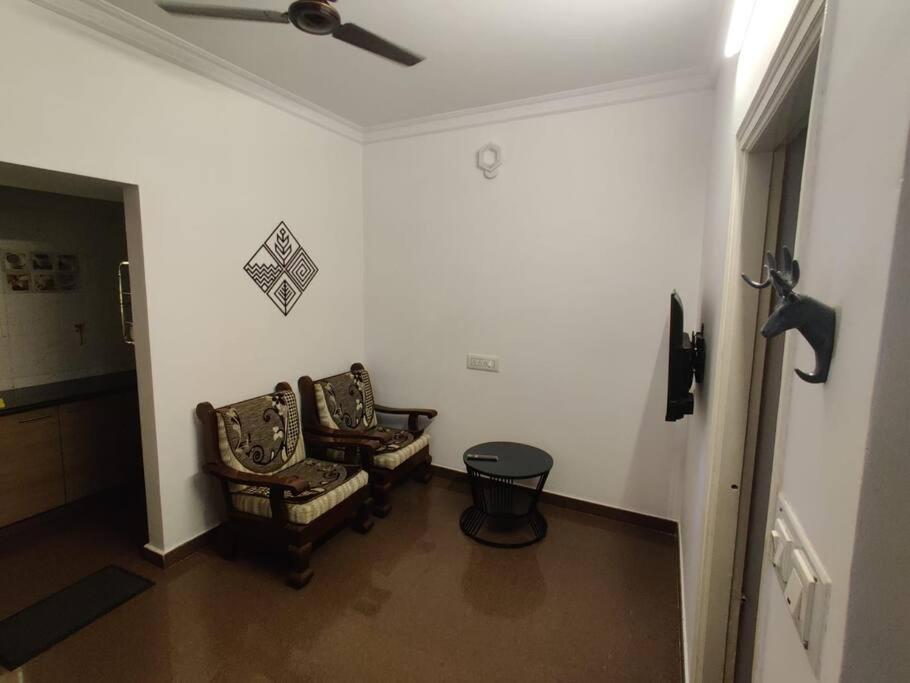 - un couloir avec deux chaises et un ventilateur de plafond dans l'établissement Euphoria, a peaceful sanctuary, à Bangalore