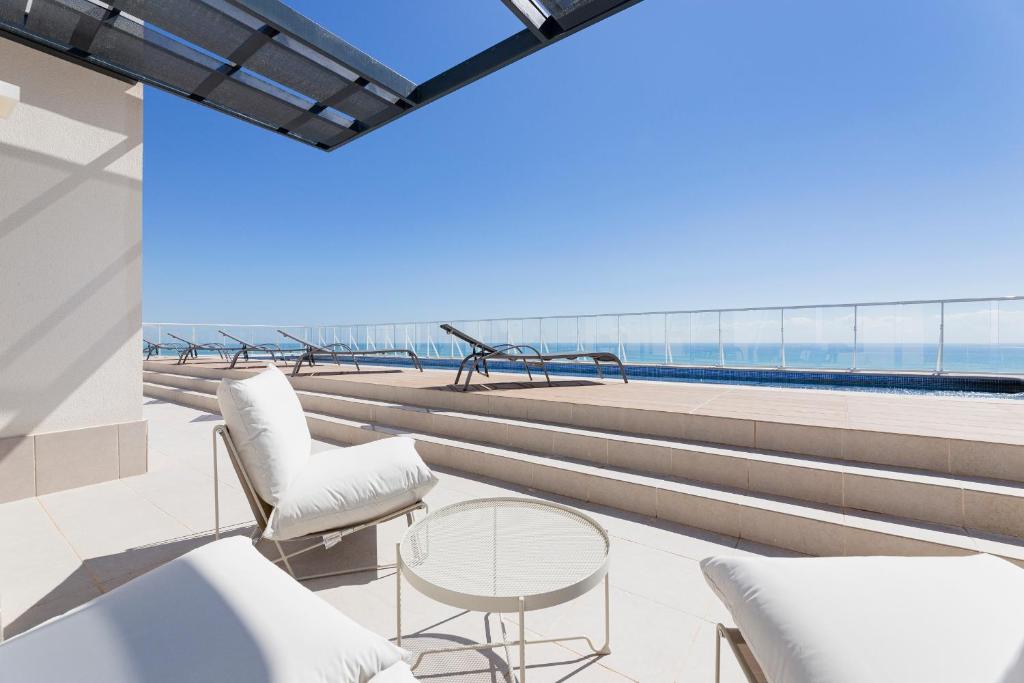 uma vista para a praia a partir da varanda de um edifício em Apartamentos en Canet al mar, junto playa y con piscina em Canet de Berenguer